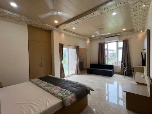 a bedroom with a bed and a couch in a room at Kaizen Living in Guwahati