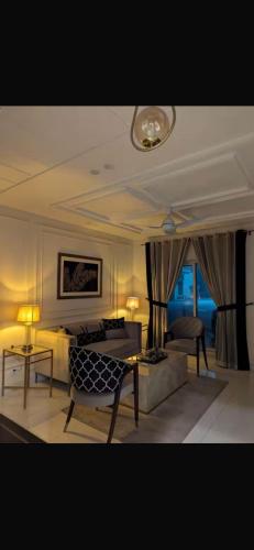 a living room with a couch and a bed and tables at Global properties in Faisalabad