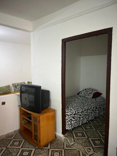 a bedroom with a tv and a bed in a mirror at Catalan in Martil