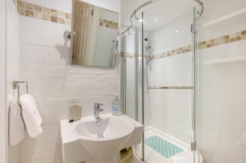 a white bathroom with a sink and a shower at 2 Bed in Cromer oc-2309 in Cromer