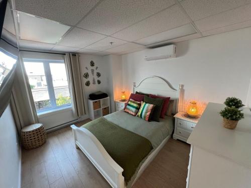 a bedroom with a large bed and a window at Appartement 2 - Est in Rimouski