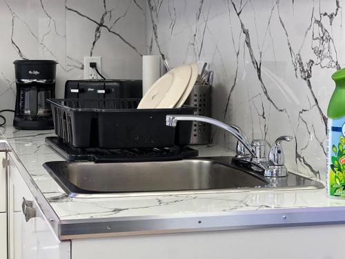 a kitchen sink with a dish drying rack next to it at Appartement 2 - Est in Rimouski