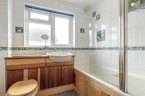 a bathroom with a sink and a toilet and a tub at 4 Bed in Ilkley oc-ds168 in Ilkley