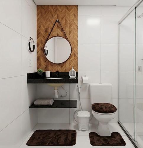 a bathroom with a toilet and a mirror at Apto Tropical - Enseadas dos Corais in Cabo de Santo Agostinho