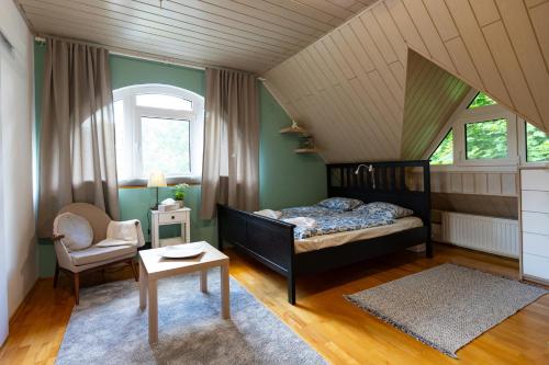 a bedroom with a bed and a chair at Sári Apartman in Balatonalmádi