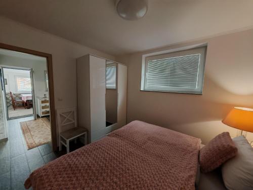 a bedroom with a bed and a window and a mirror at Apartman Leo in Mariánské Lázně