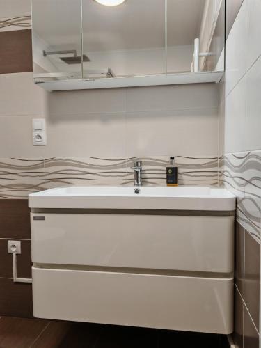 a white kitchen with a sink in a room at Apartman Leo in Mariánské Lázně