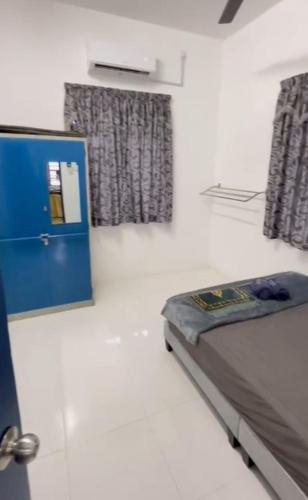 a bedroom with a bed and a blue door and windows at Akif Stella Guesthouse in Marang