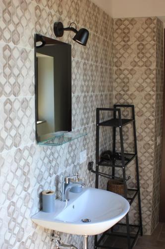 a bathroom with a sink and a mirror on the wall at B&B del Borgo in Ortezzano