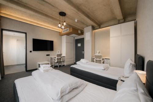 a room with two beds and a flat screen tv at Olive INN Berlin in Berlin