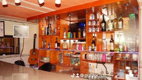a bar with a lot of bottles of alcohol at Hostal Juyanis in Otavalo