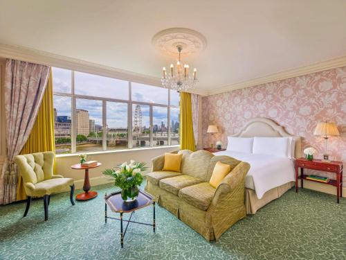 a hotel room with a bed and a couch at The Savoy in London