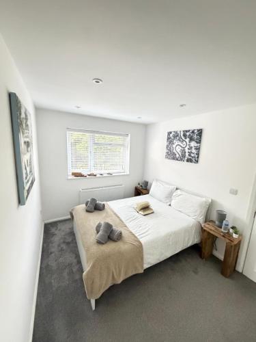 a white bedroom with a bed with towels on it at Stylish Charming London Flat Ruislip -Free Parking in Ruislip
