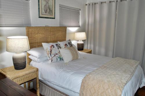 a bedroom with a bed with white sheets and pillows at Bona Ngwenya Lodge & Safaris in Marloth Park
