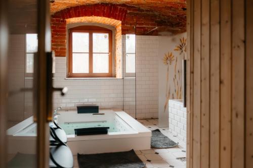a bath tub in a bathroom with a window at Folwark Wielka Wieś in Główczyce