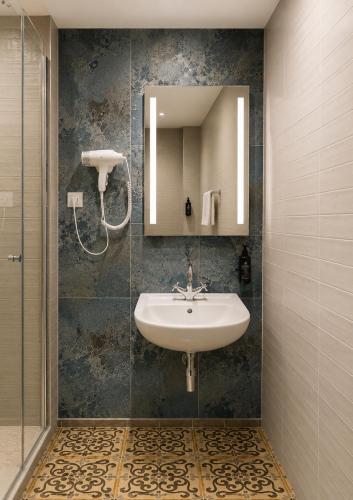 a bathroom with a sink and a mirror at Hotel Viki in Vienna
