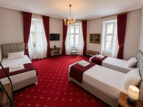 a hotel room with two beds and a red carpet at Hotel Viki in Vienna