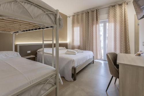 a bedroom with two bunk beds and a desk at Nova Suite in Calatafimi