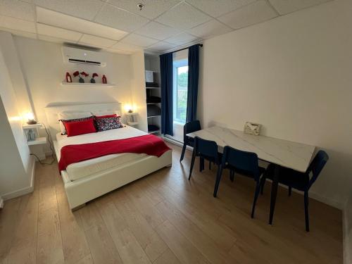 a bedroom with a bed and a table with chairs at Appartement 1 - OUEST in Rimouski