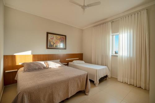 a bedroom with a bed and a window at Souza Apart 1 - Apartamentos completos com muito aconchego in São Thomé das Letras