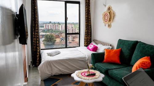 a living room with a green couch and a bed at Stylish 10th Floor Studio with great Views ,Fast Wi-Fi and Secure in Nairobi