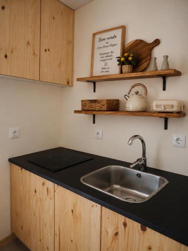 a kitchen with a sink and a counter top at Solar dos Caseiros in Macieiro da Maia