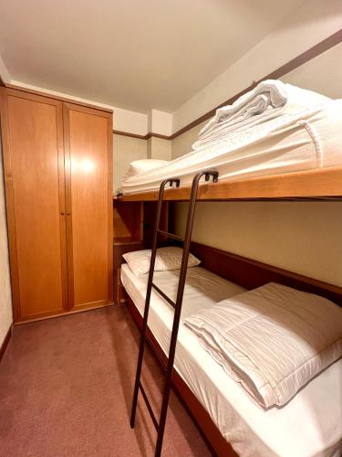 a bedroom with two bunk beds and a cabinet at Monolocale Des Alpes 204 in Madonna di Campiglio