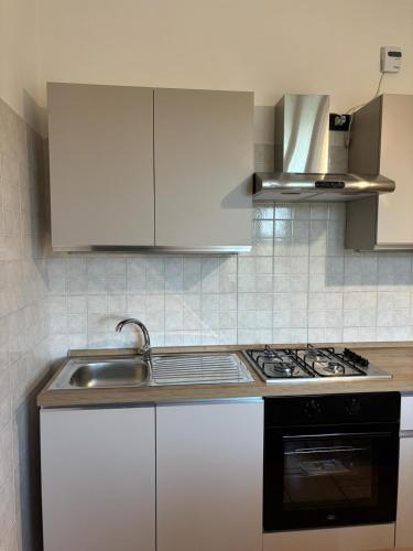 a kitchen with white cabinets and a sink and a stove at Casa Ciccone-L'Aquila in Tornimparte