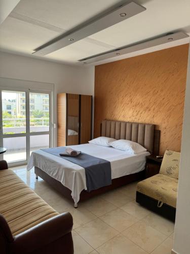 a bedroom with a large bed and a chair at Apartments Flamida in Ulcinj