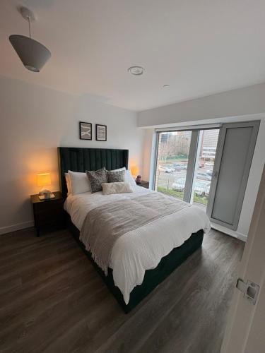a bedroom with a large bed and a large window at Modern 2BD 2 bathroom apartment close to city centre in Manchester