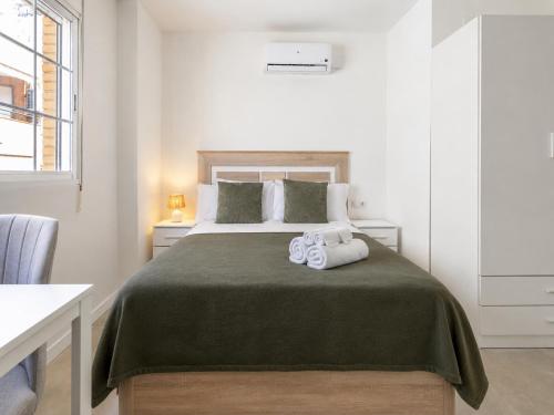 a bedroom with a bed with two towels on it at Sanchis Studios in Alicante