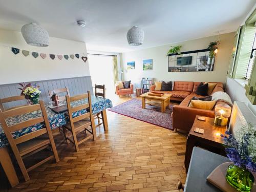 a living room with a couch and a table at Vale View Cottages -The Coach House, Great location in Prestatyn! in Prestatyn