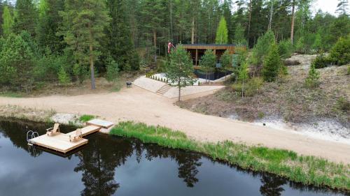 a house on a lake with a dock at AVOTUPJi in Plānupe