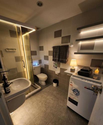 a bathroom with a sink and a toilet and a tub at Zcape garden by lsqstays in Ban Rangeng