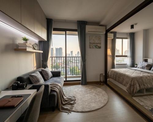 a bedroom with a couch and a bed and a window at Zcape garden by lsqstays in Ban Rangeng