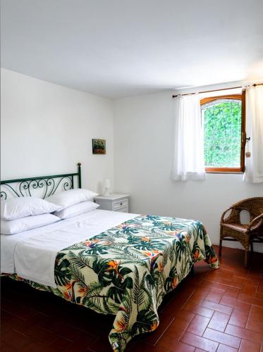 a bedroom with a bed with a colorful blanket on it at Casa Maddalena in Monteriggioni