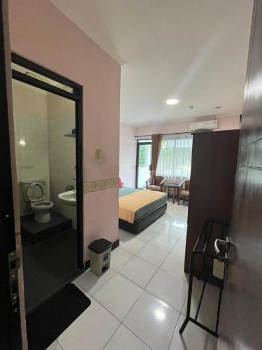 a room with a bedroom with a bed and a bathroom at Wisma Pakuan Syariah Hotel in Bogor