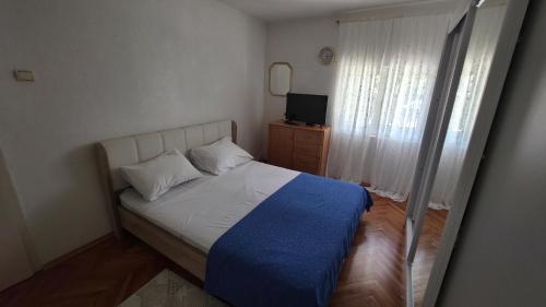 a small bedroom with a bed and a television at Apartments MiMa in Kotor