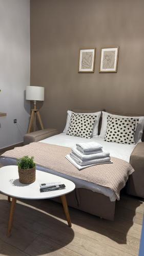 a bedroom with a large bed and a table at Bamboo House Syros No1 in Ermoupoli