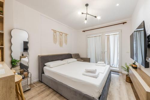 a bedroom with a large bed and a television at NooN Apartment | Sofo Duni by PikHost in Dhërmi