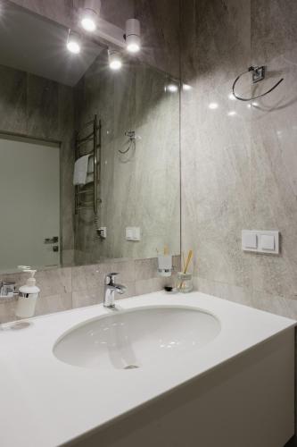 a bathroom with a white sink and a mirror at Вікторі Апарт in Kyiv