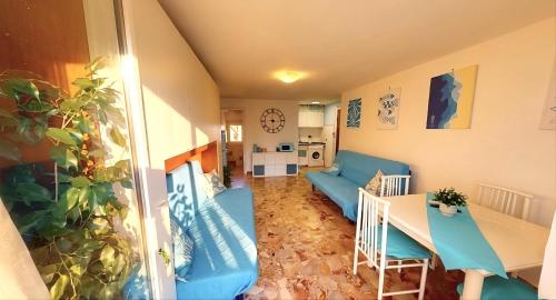 a living room with a blue couch and a table at Casa vacanza 'Note di mare' in Torvaianica
