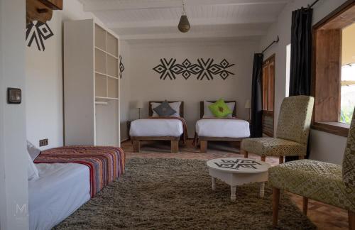 a bedroom with two beds and a table and chairs at Les Dunes de Dakhla in Dakhla