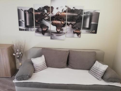 a living room with a couch with a bunch of paintings at Apartma Dečko Rogaška in Rogaška Slatina