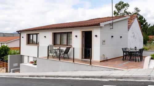 a small white house with a deck at Terraza del atardecer in Vilar