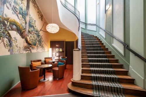 a spiral staircase in a lobby with a table and chairs at Best Western Dijon Centre Gare in Dijon