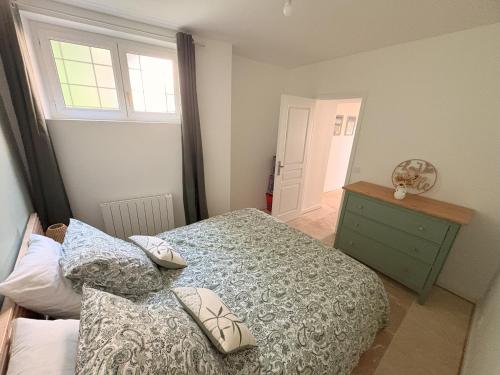 a bedroom with a bed and a dresser and a window at Entre Loire & Château in Chaumont-sur-Loire