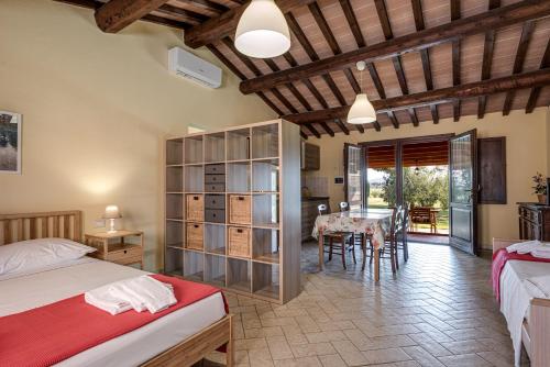 a bedroom with two beds and a dining room with a table at Agriturismo Il Pescinone in Venturina Terme