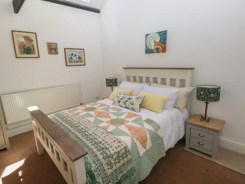 a bedroom with a bed with a quilt on it at Daffodil Cottage in Treorky