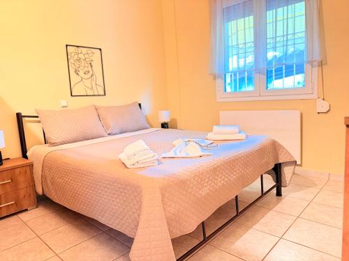 a bedroom with a bed with towels on it at Shell-paralia ofriniou in Ofrínion